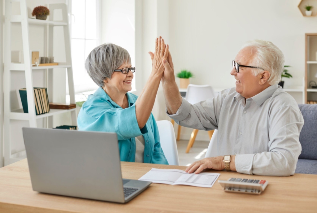 Older couple smiling over bill paying