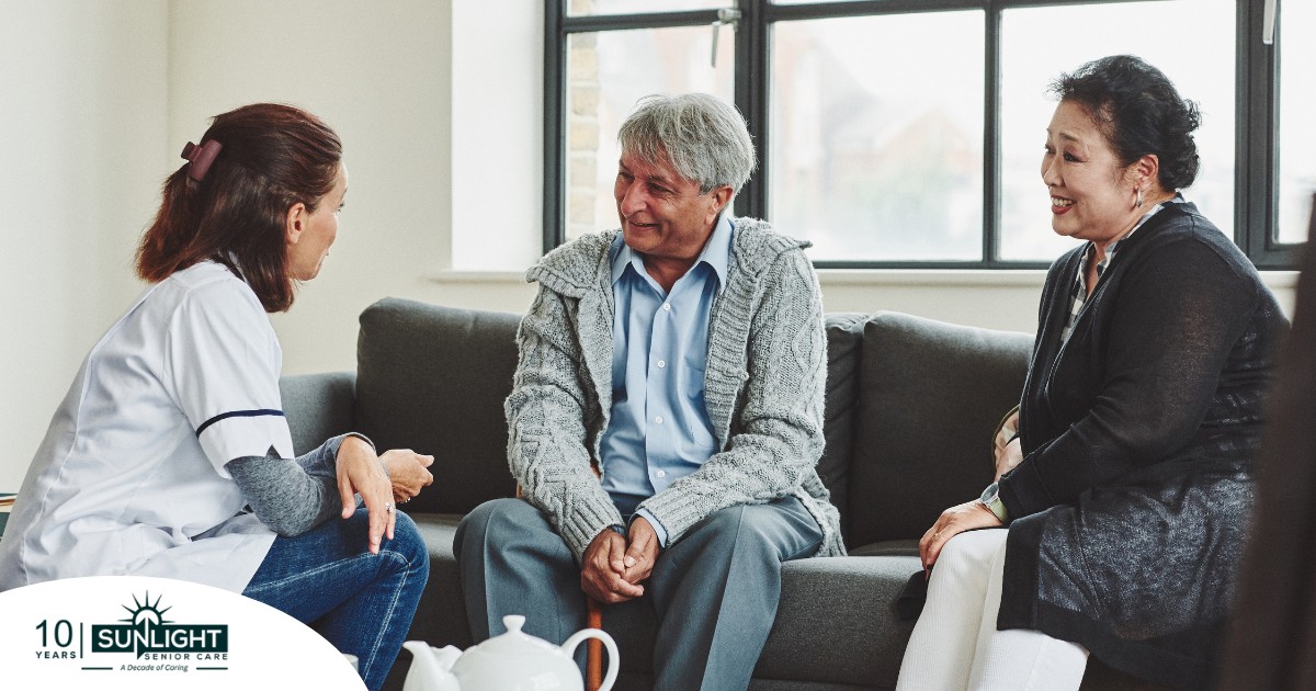 A caregiver talks with an elderly couple representing the kind of communication that professional caregivers need to have to anticipate client needs.