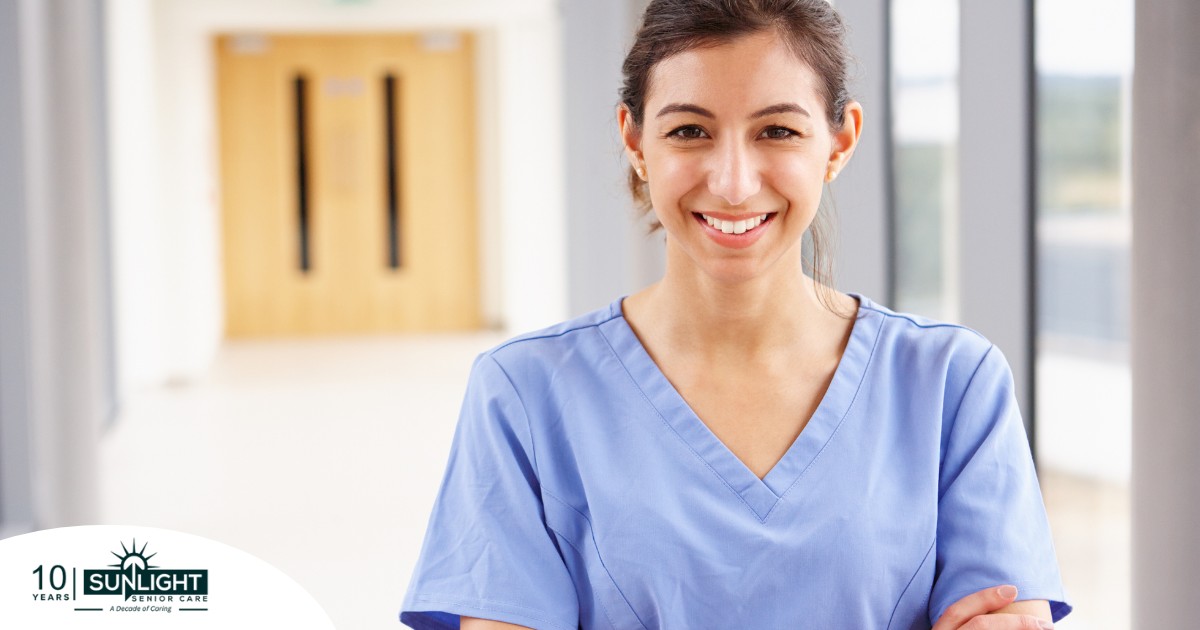 A woman in scrubs smiles, representing the good results that can come when caregivers branch out to become CNAs.