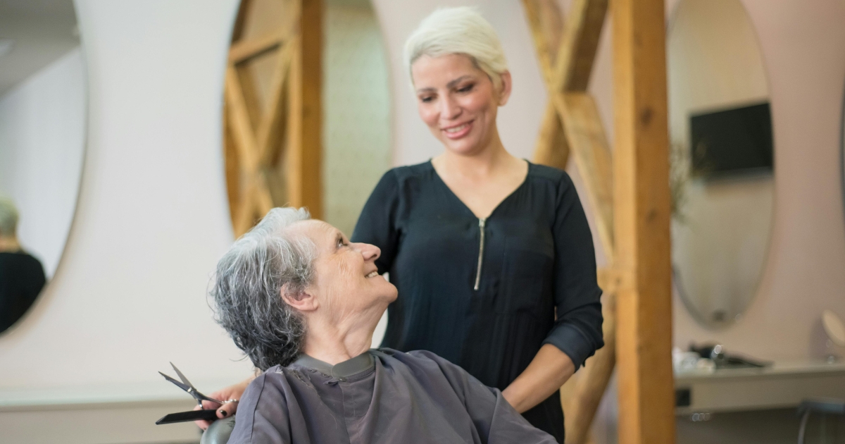 A senior woman smiles at her caregiver in a warm, friendly setting. This image reflects the compassionate senior home care services offered in Carlisle.