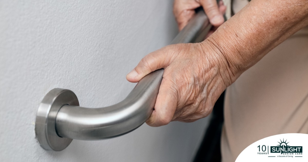 An older adult uses a grab bar representing one of the home modifications that is helpful for fall prevention for elderly adults.