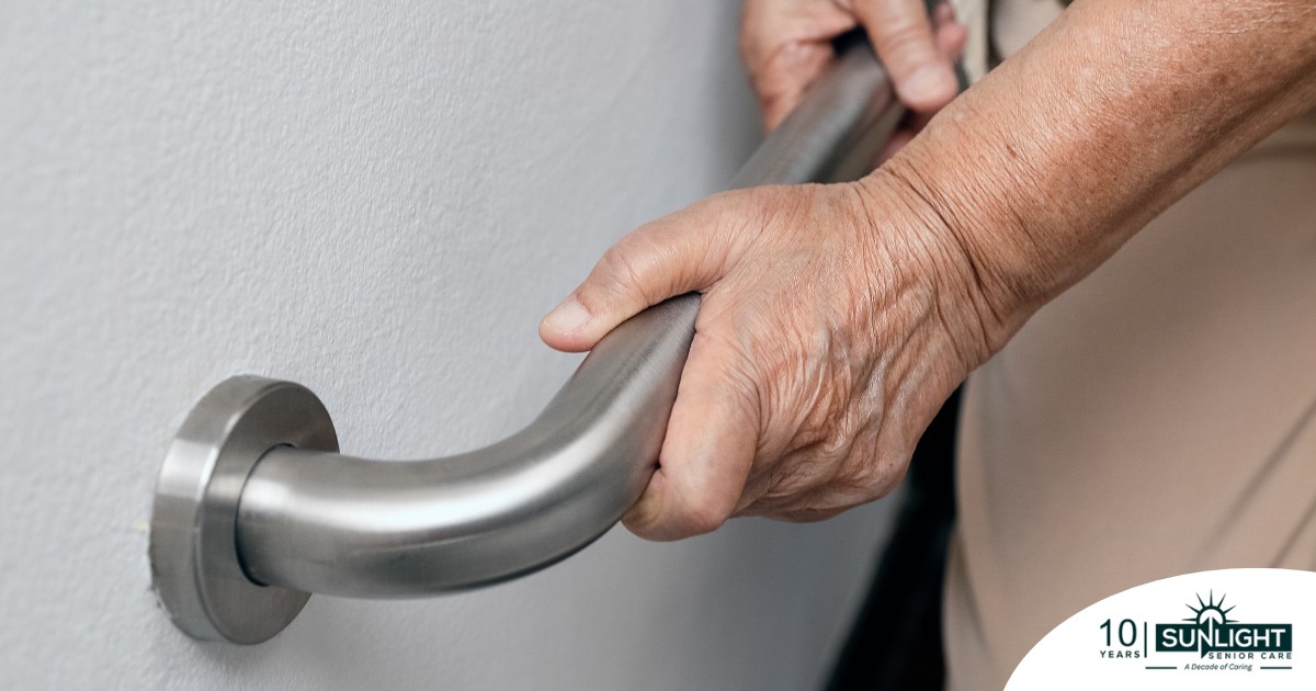 An older adult uses a grab bar representing one of the home modifications that is helpful for fall prevention for elderly adults.