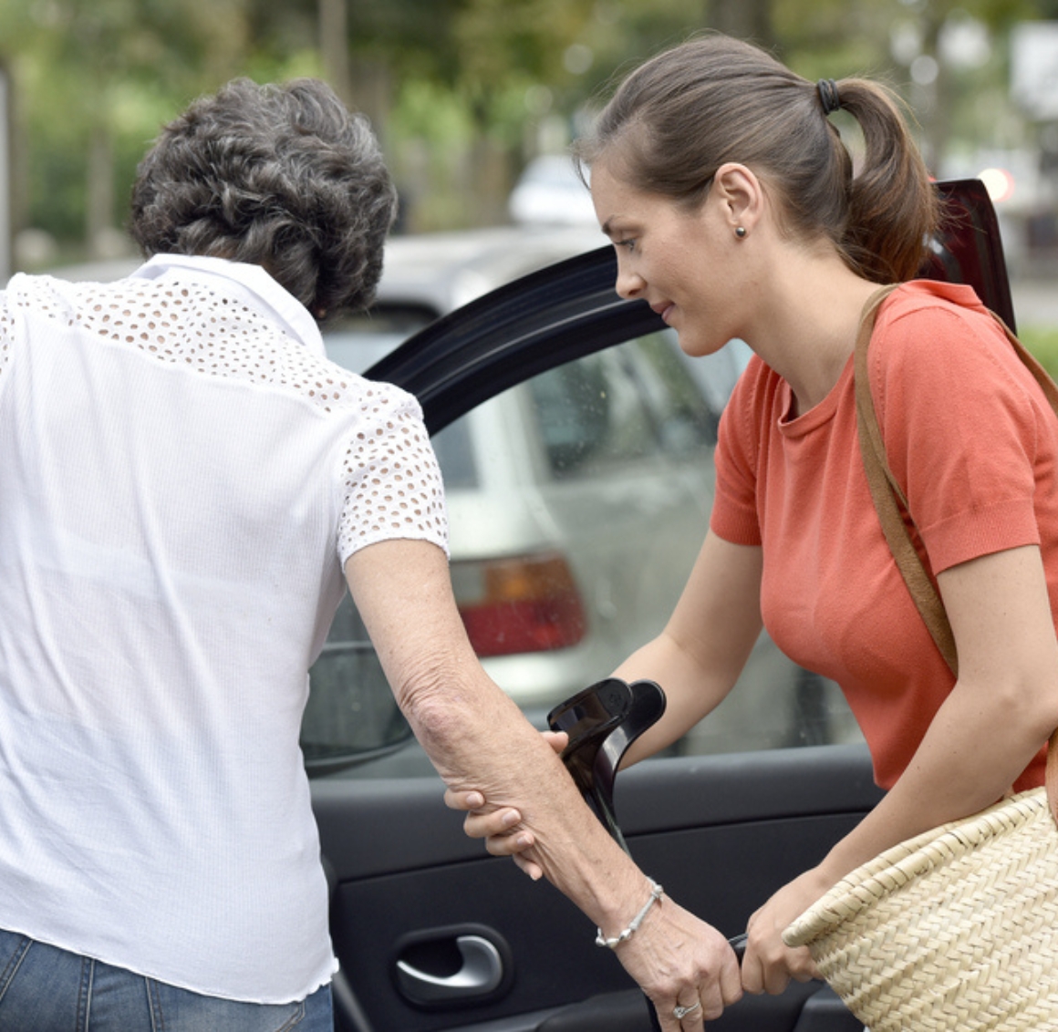 Mobility Assistance (1) Caregiver providing Mobility Assistance in Des Moines by helping a senior woman safely get out of a car with supportive guidance.