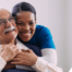 a graphic showing What a Week of Elder Care at Home Really Looks Like with a smiling caregiver and client